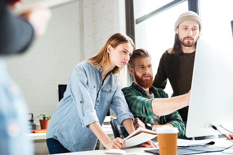 a group of people looking at a computer screen